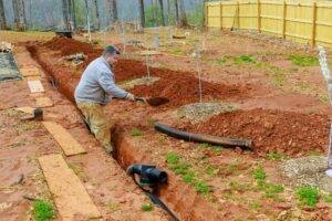 Installing storm drainage pipe into a trench drain in order to drain rainwater